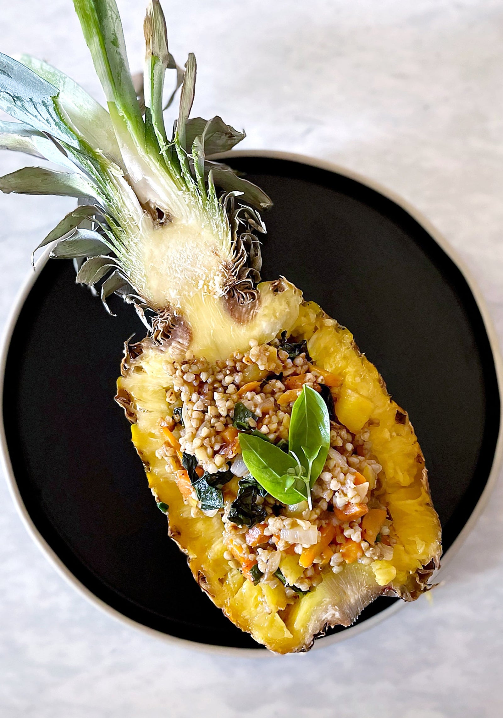Pineapple fried buckwheat groats served in hollowed out pineapple