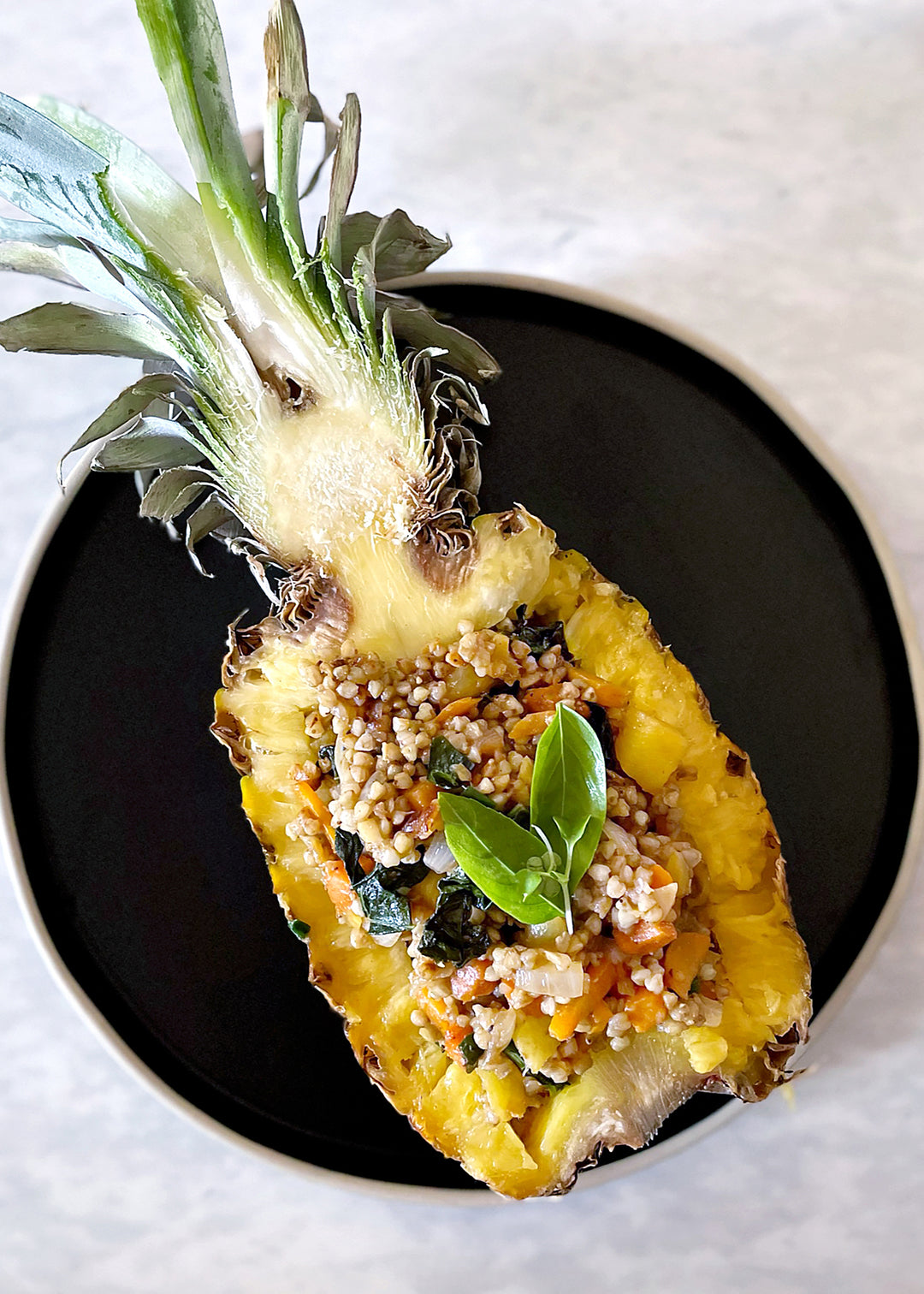 Pineapple fried buckwheat groats served in hollowed out pineapple