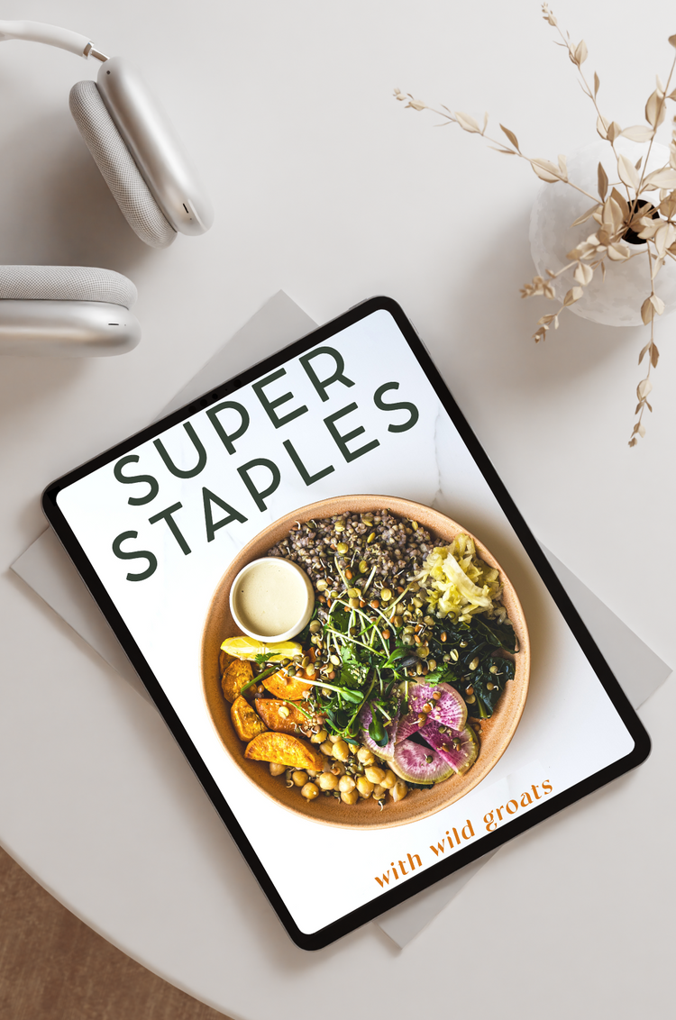 Super Staples recipe ebook displayed on iPad with white headphones on desk