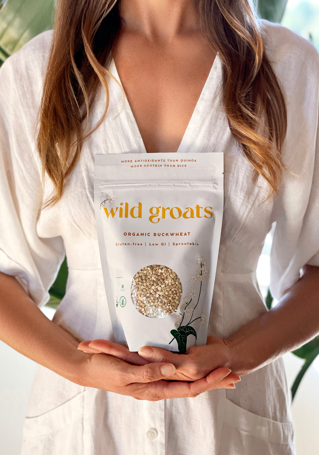 Woman in white dress holding Wild Groats bag